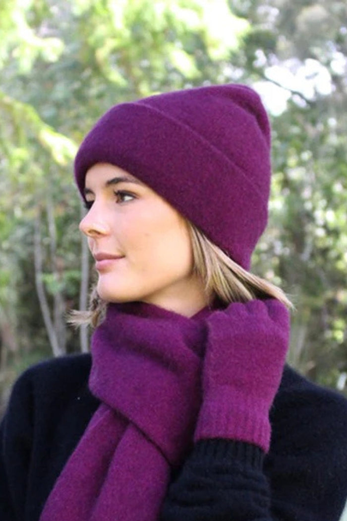 Woman wearing berry purple possum and merino wool beanie and scarf. Soft, warm and lightweight winter beanie