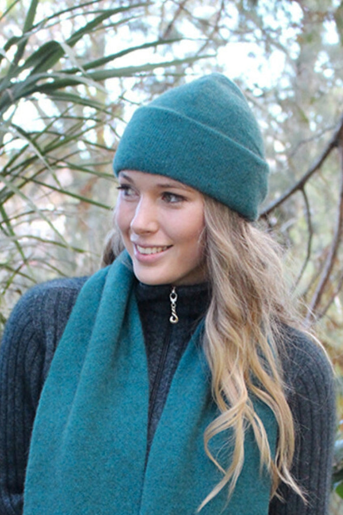 Woman wearing teal blue possum and merino wool beanie and scarf. Soft, warm and lightweight winter beanie
