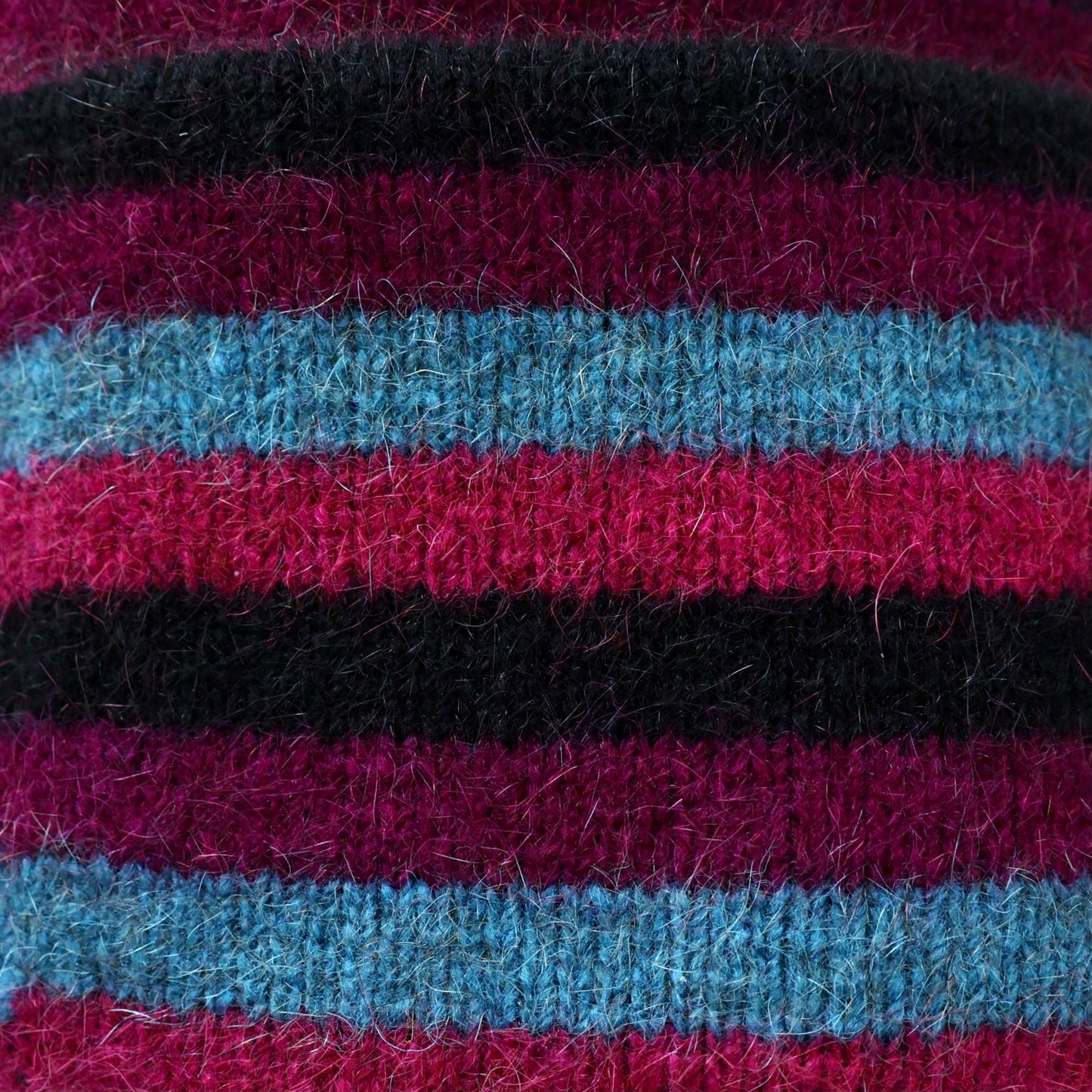 Purple, black and blue striped possum and merino wool beanie close up of fabric. Warm, comfortable and soft merino wool unisex beanie