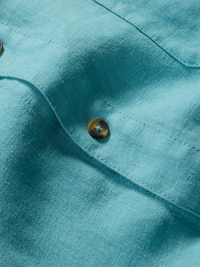 Close-up of a turquoise fabric with a button