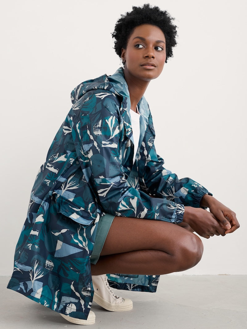Woman wearing a blue patterned raincoat on a white background