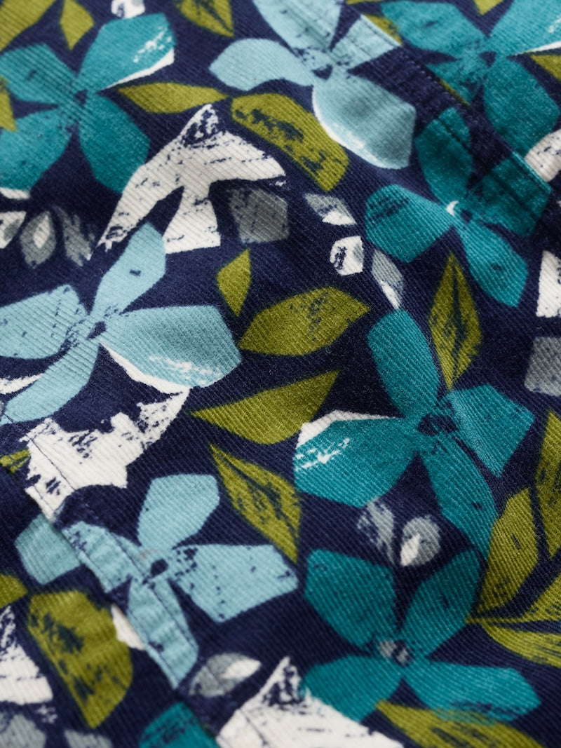 Close-up of organic cotton denim fabric with blue and green floral pattern