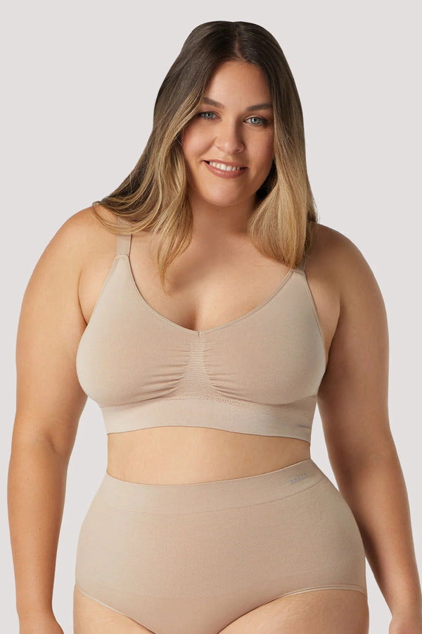 Woman wearing nude Bamboo Adjustable Crop bra. Sustainable, wire free bra with adjustable straps. Bra with removable cups