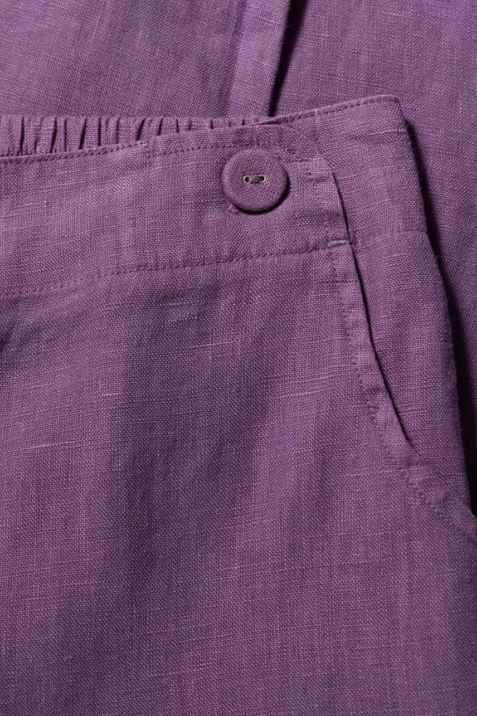 Close-up of a purple fabric with a button on a dark background