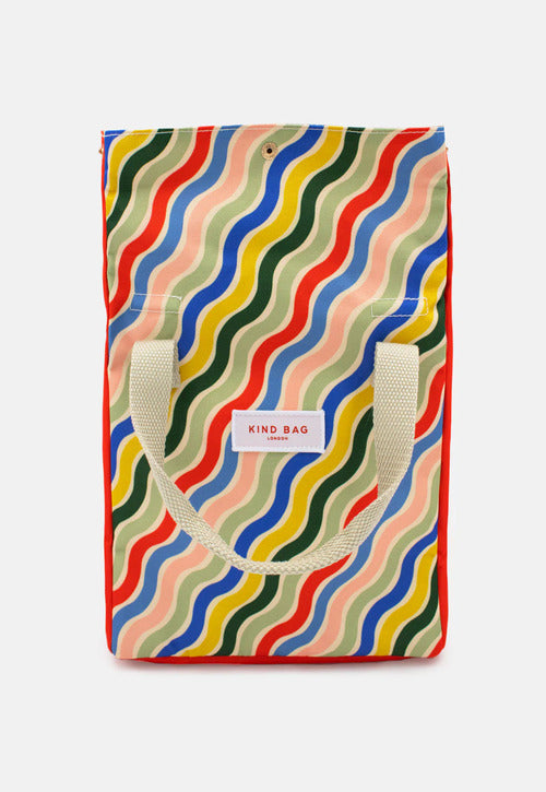 Kind bag reusable colourful rainbow lunch bag being held by woman. Lunch bag made from 100% recycled materials, water-resistant, machine washable & features multiple pockets for organisation.