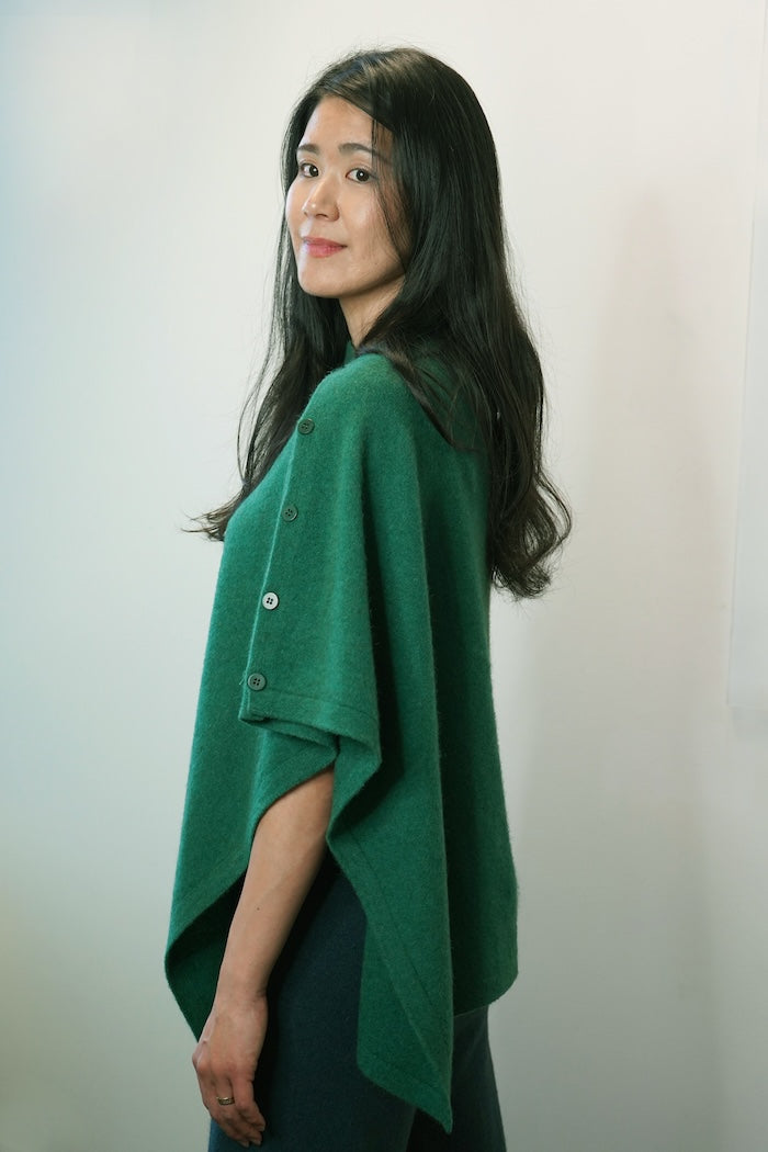 Woman wearing green merino wool, possum & silk poncho. Versatile women's warm & cosy wrap/poncho