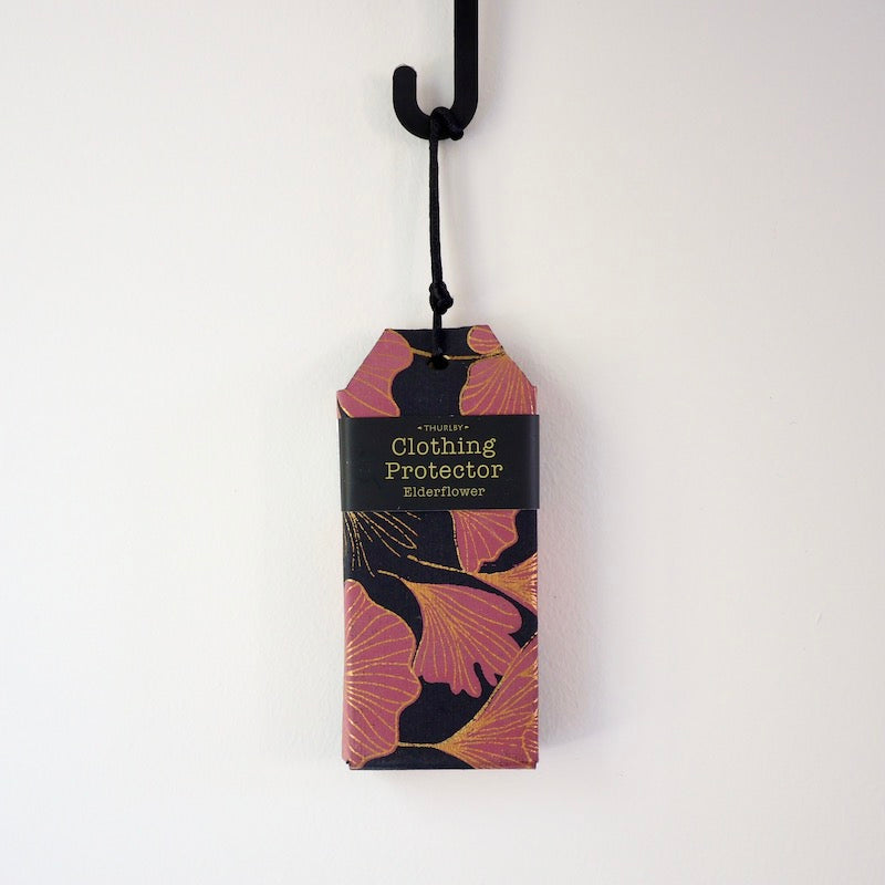 Elderflower scented clothing protector hanging on hook on white background