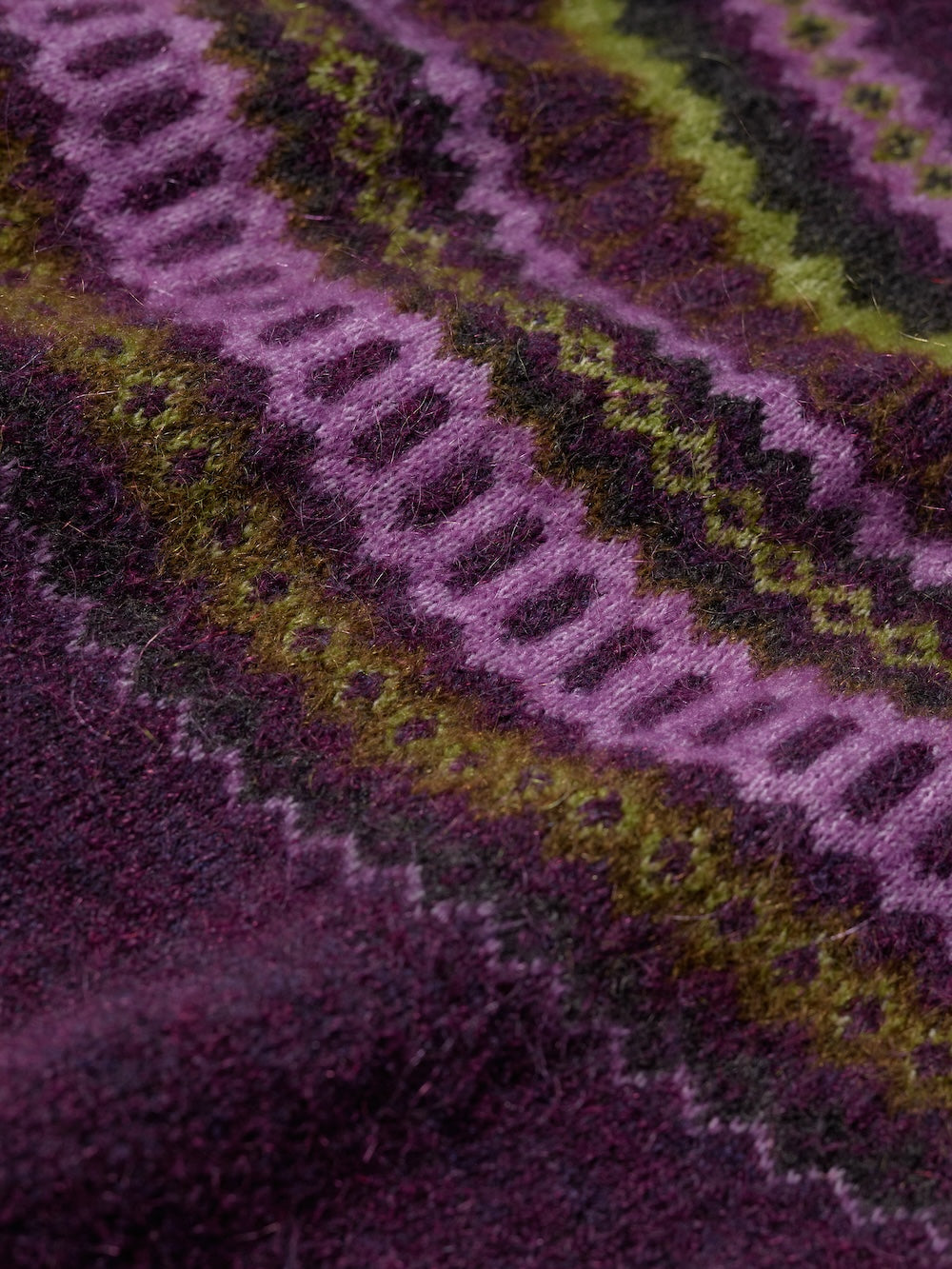 Close-up of a knitted fabric with purple and green pattern