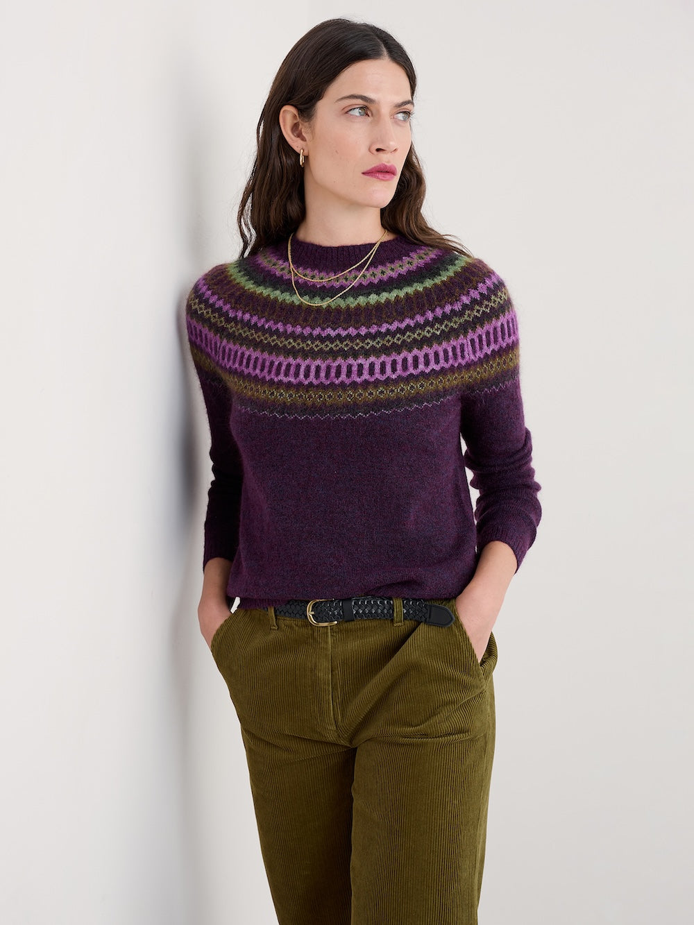 Woman wearing a patterned purple sweater against a plain background