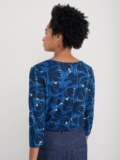 Woman wearing a blue floral patterned top against a plain background