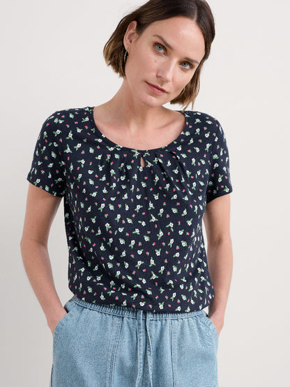 Woman wearing a navy blue floral blouse against a white background