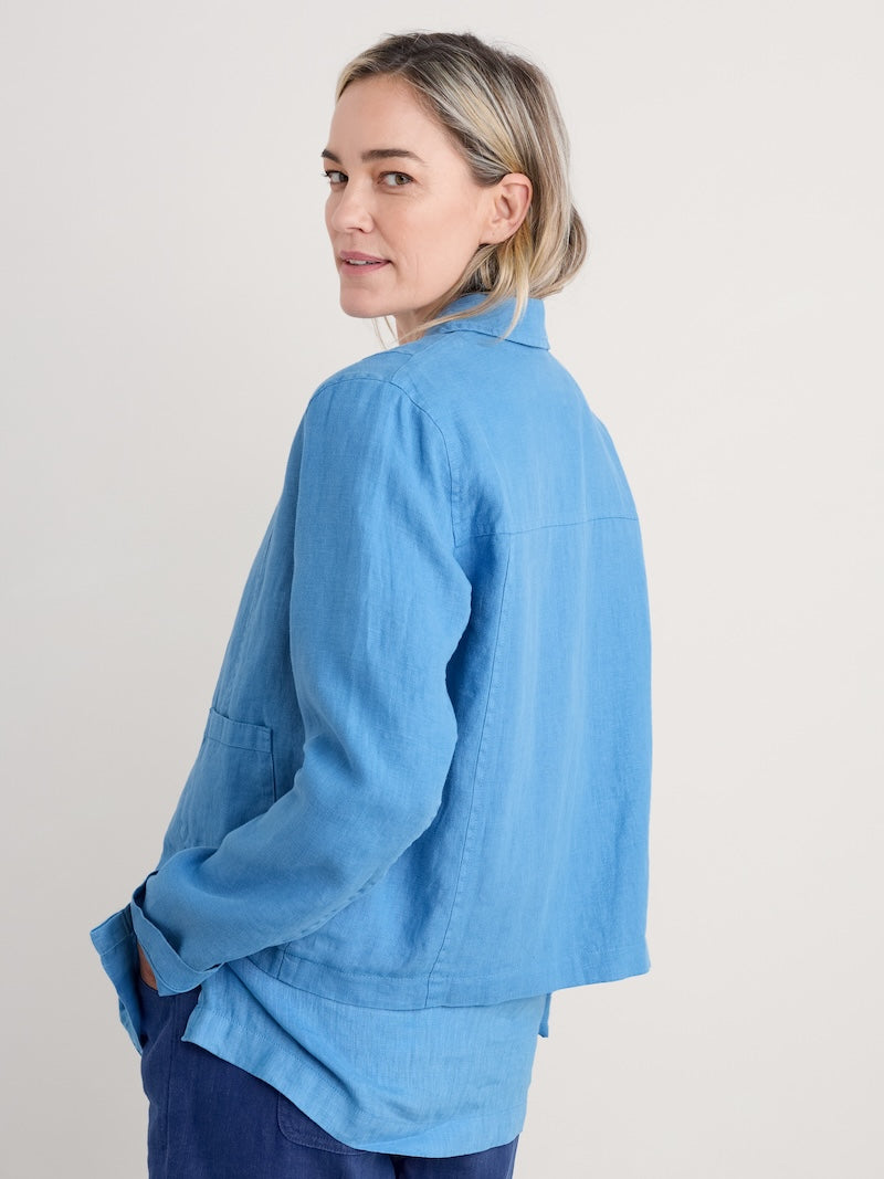 Woman wearing a light blue jacket on a plain background