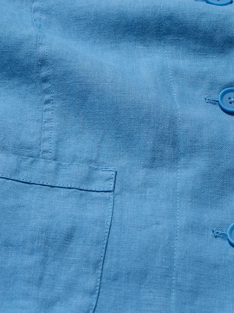 Close-up of a blue shirt with a pocket and buttons.