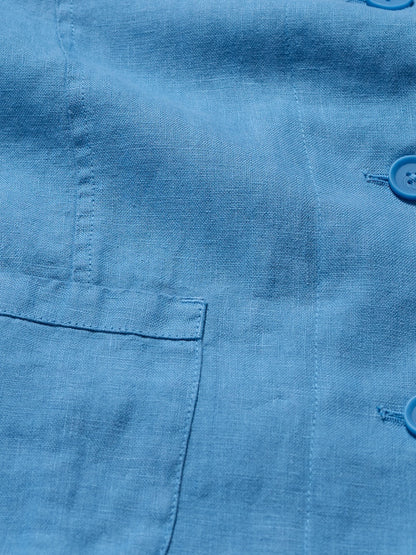 Close-up of a blue shirt with a pocket and buttons.