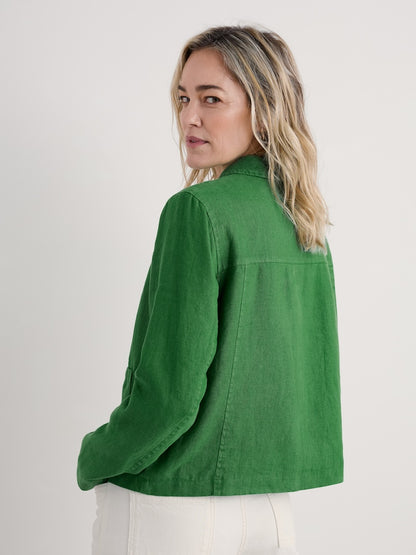 Woman wearing a green jacket on a plain background