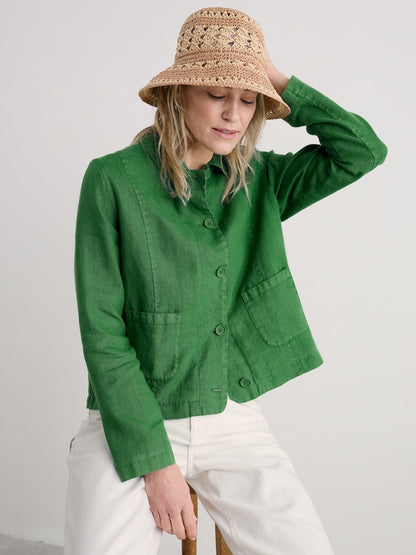 Woman wearing a green jacket and beige hat on a white background