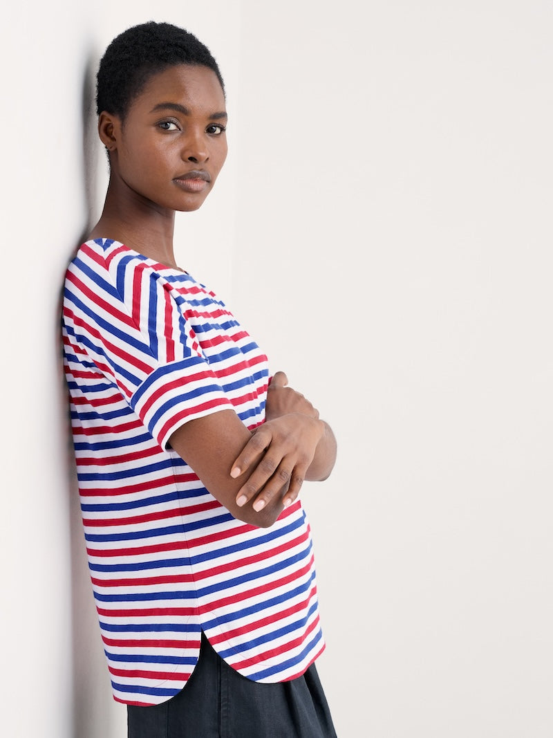 Woman wearing a red, white, and blue striped shirt against a plain background