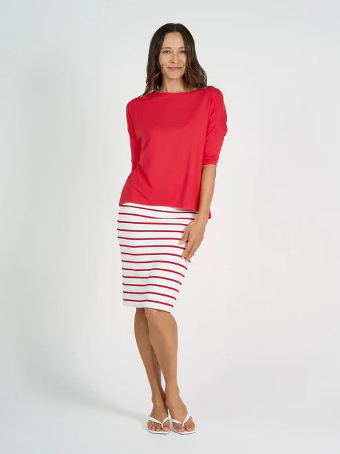 Woman wearing a red bamboo 3/4 length sleeve top and striped skirt on a white background