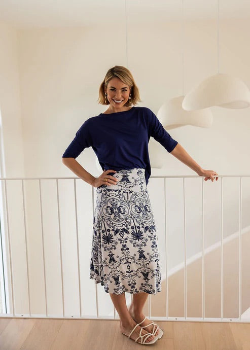 Woman wearing a blue bamboo 3/4 length sleeve top and white patterned skirt