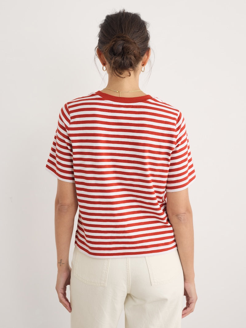 Person wearing a red and white striped shirt against a plain background
