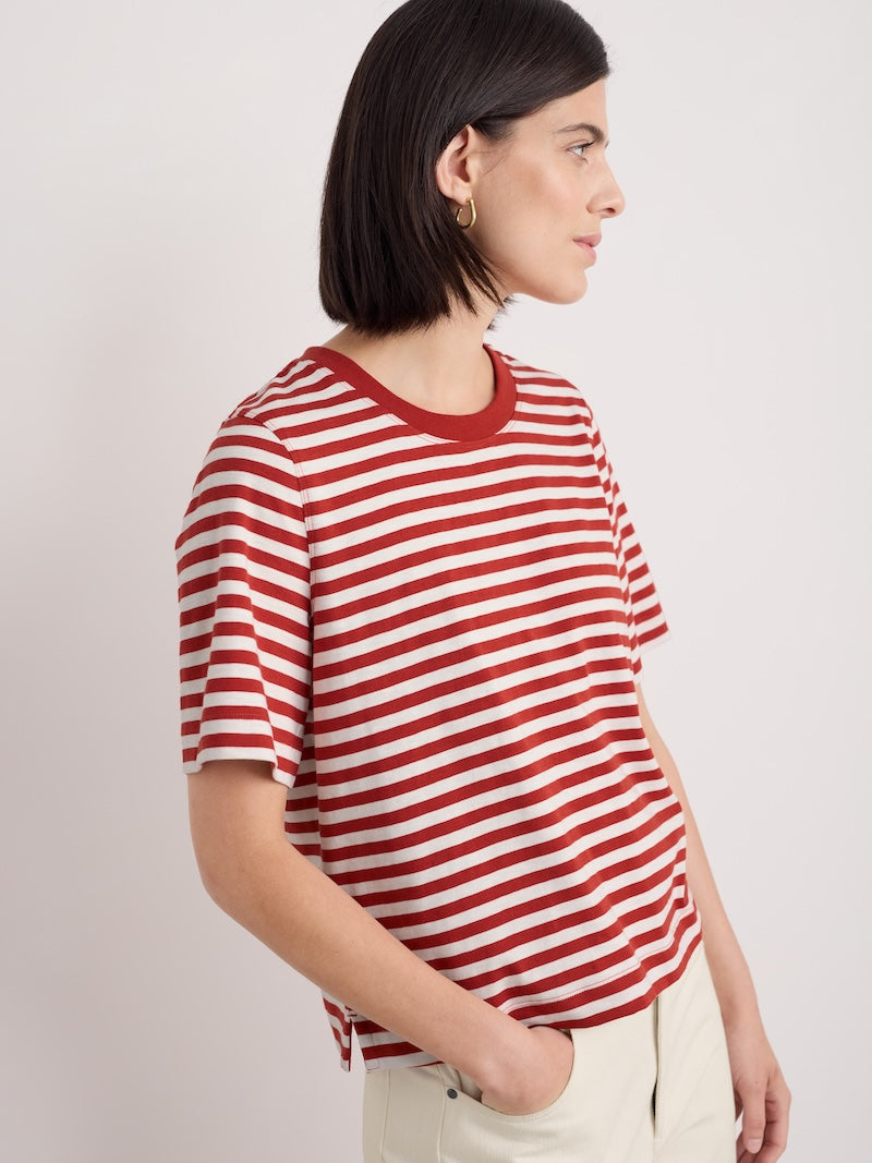 Woman wearing a red and white striped shirt against a plain background