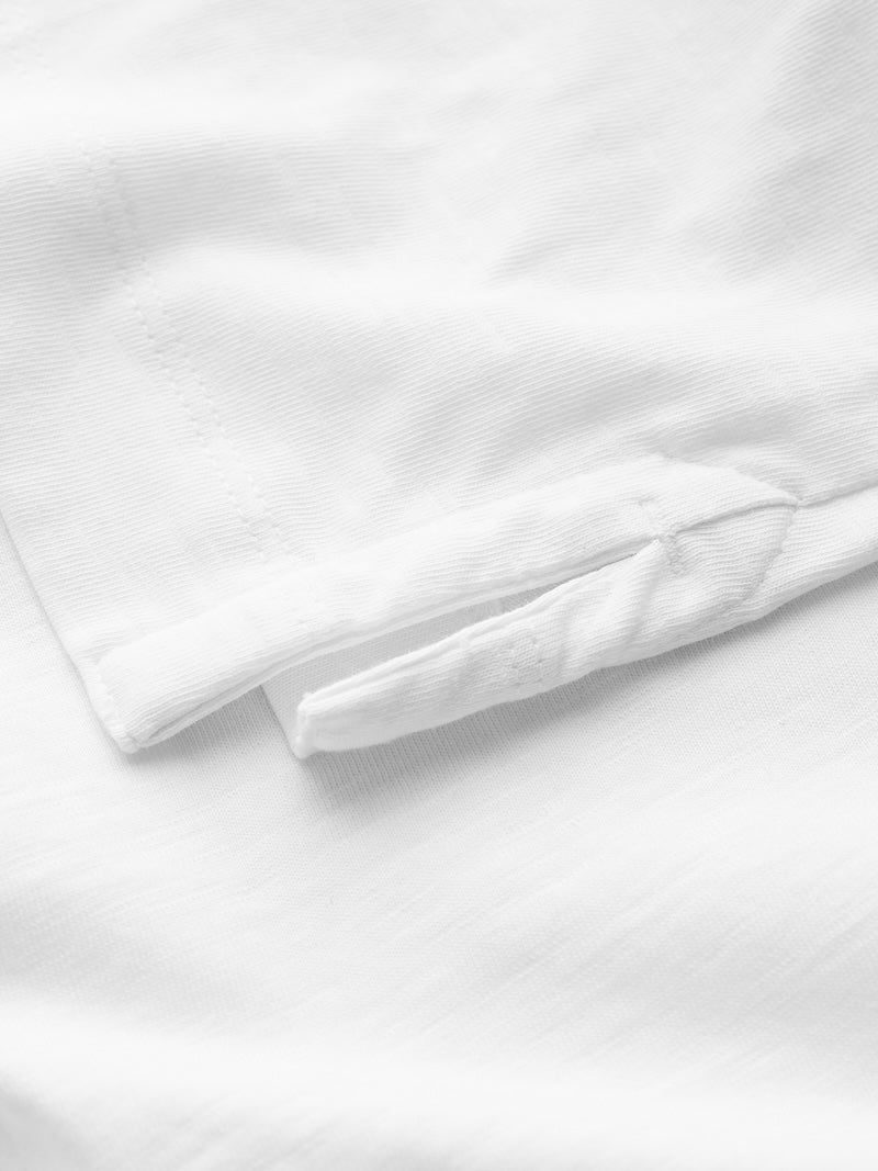 Close-up of white shirt with a subtle texture on a white background