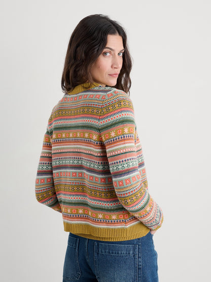 Woman wearing a colourful patterned cardigan on a plain background
