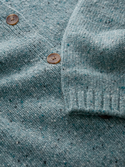 Close-up of a teal cardigan with brown buttons