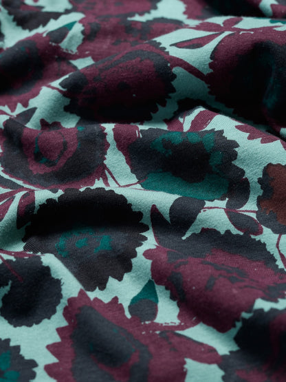 Close-up of fabric with a floral pattern in purple, black, and green.