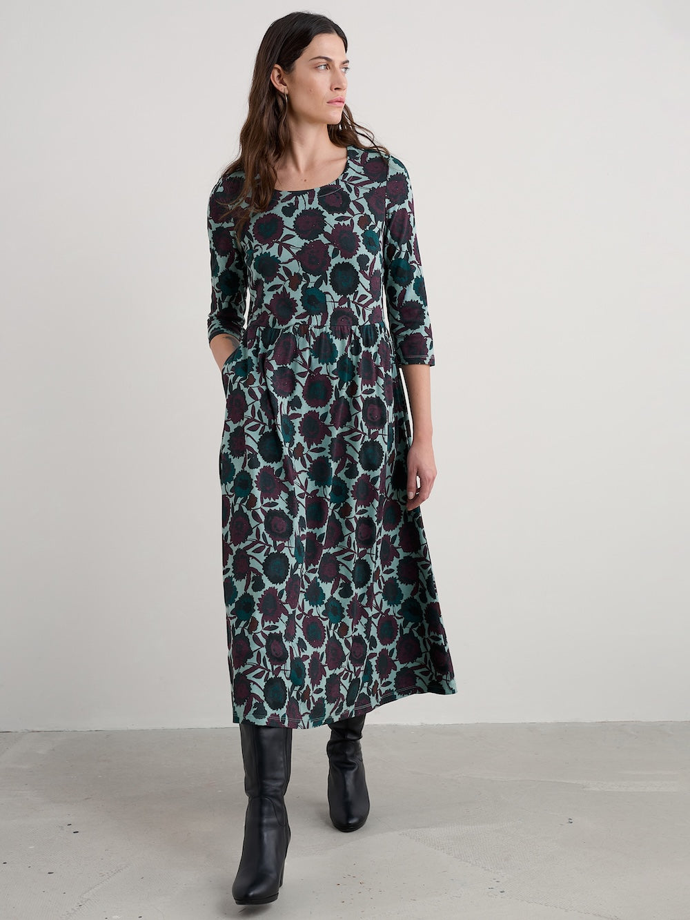 Woman wearing a long floral dress against a white background