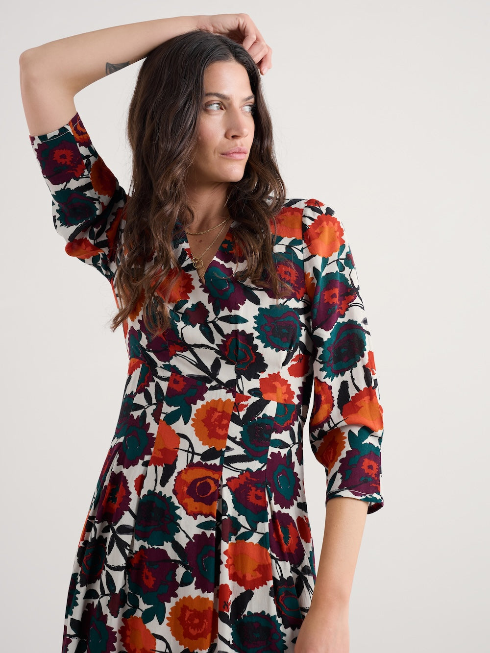 Woman wearing a colorful floral dress on a white background
