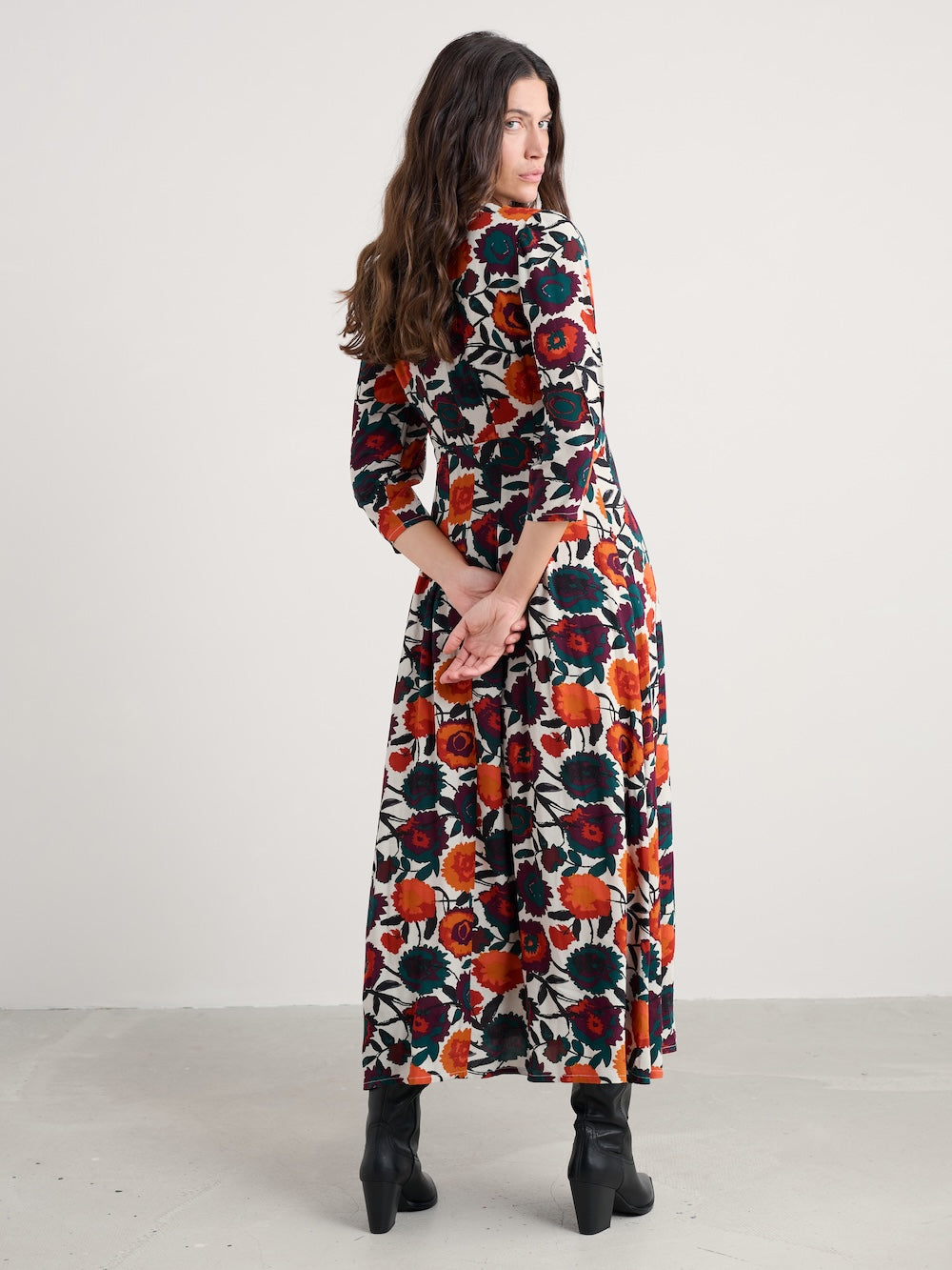 Woman wearing a long floral dress with a white background
