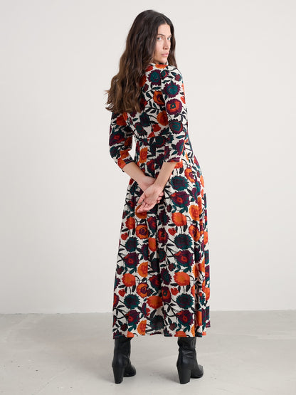 Woman wearing a long floral dress with a white background