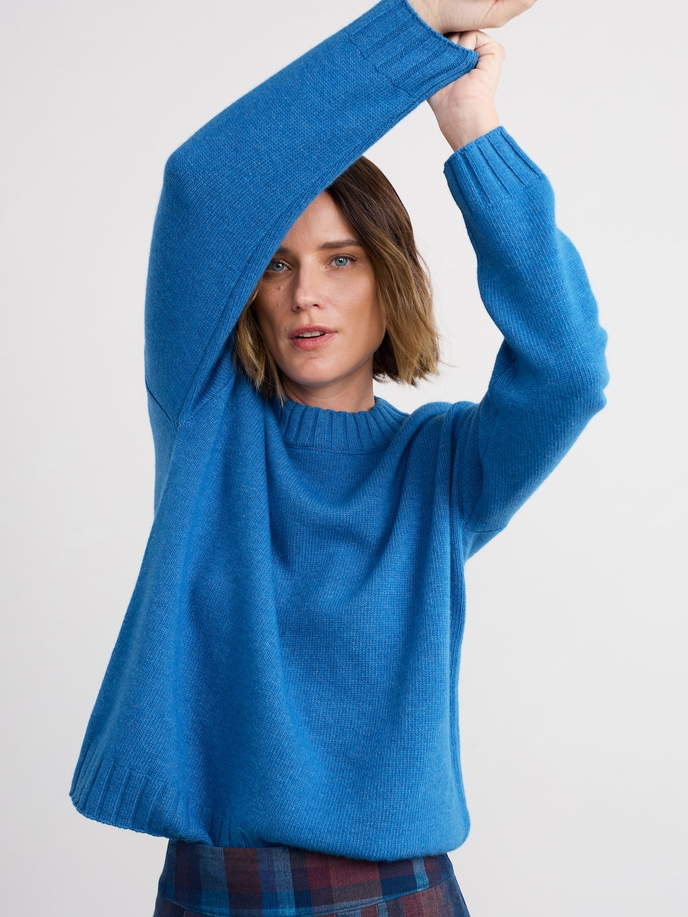 Person wearing a blue sweater with a plain background