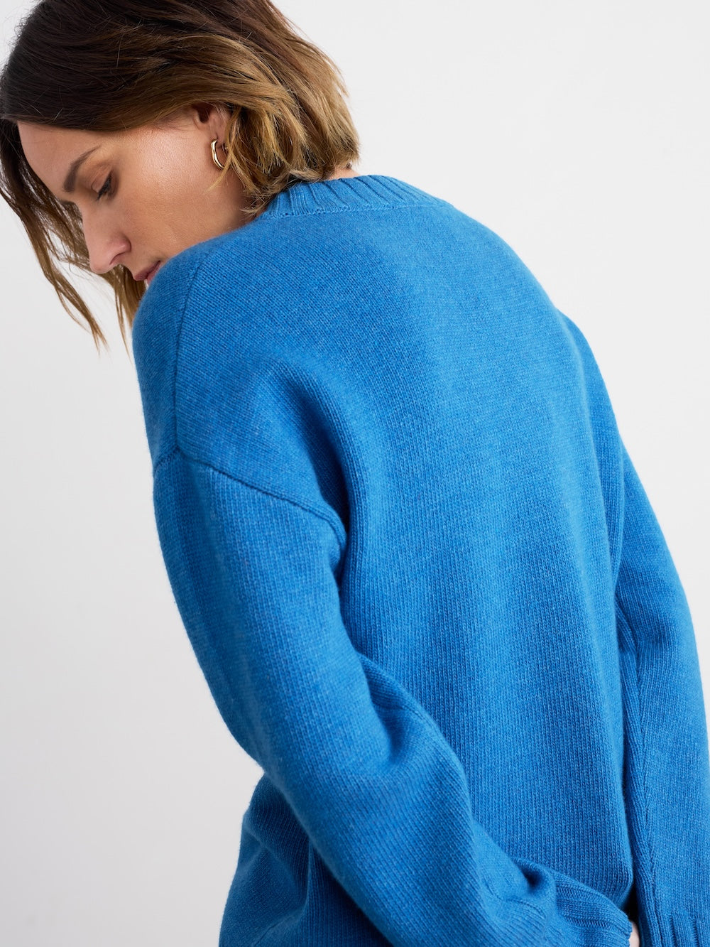 Person wearing a blue sweater on a white background