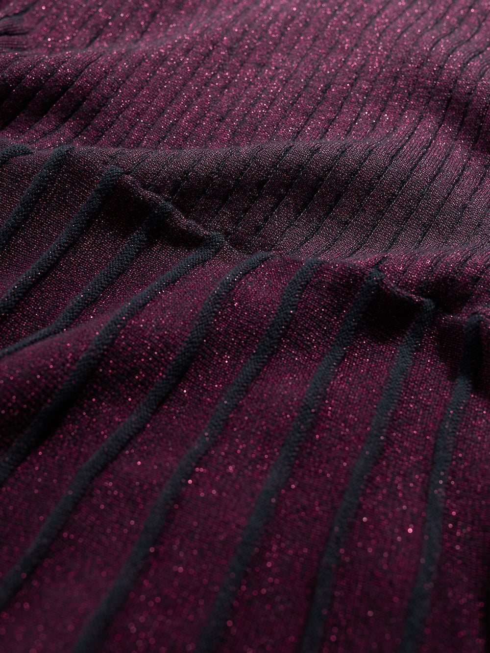 Close-up of a dark purple fabric with ribbed texture