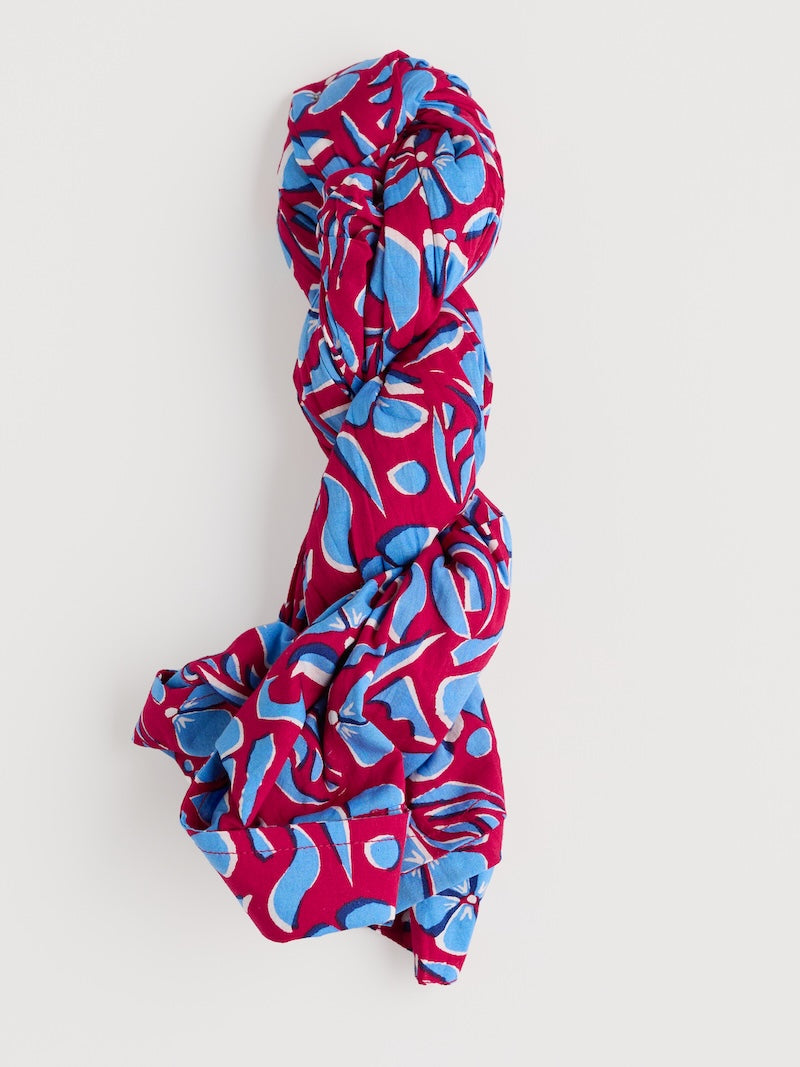 Red and blue patterned rolled up shirt on a white background