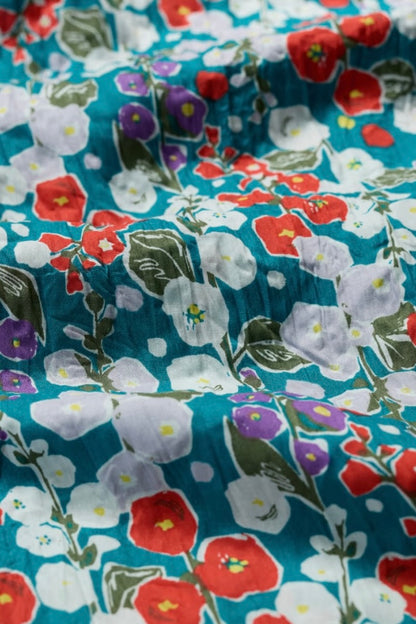 Floral fabric with red, white, and purple flowers on a blue background