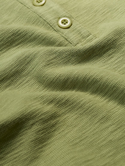 Close-up of a green textured shirt with buttons
