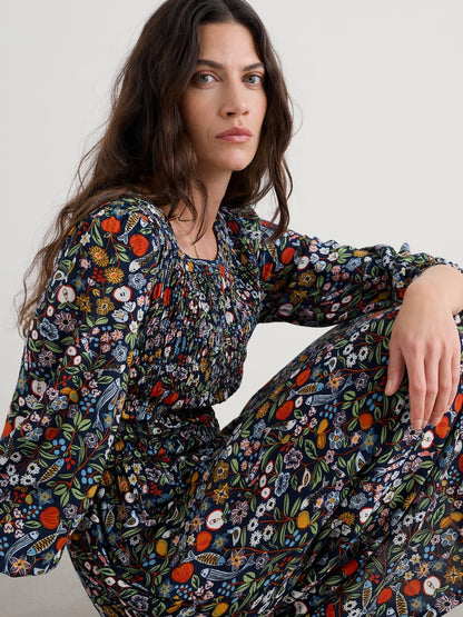 Woman wearing a floral dress sitting on a white surface