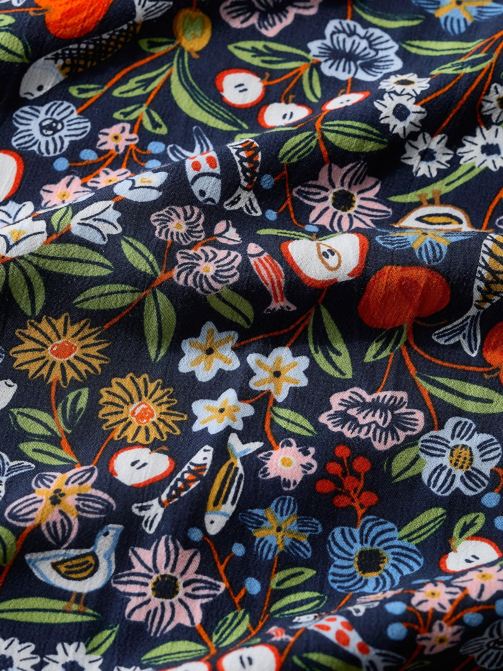 Colorful floral and animal patterned fabric on a dark background