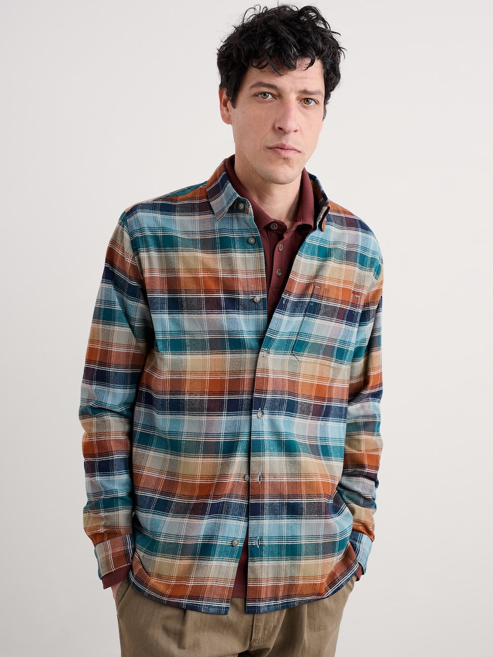 Man wearing a plaid shirt with a neutral background