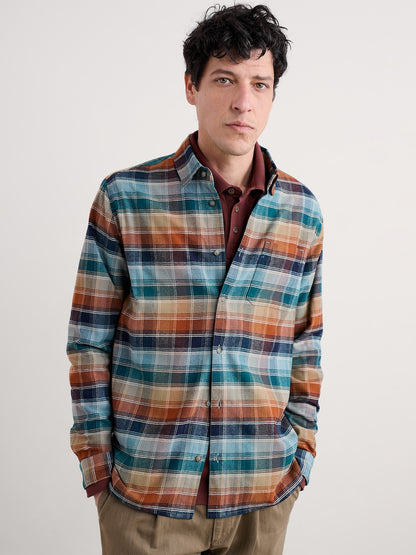 Man wearing a plaid shirt with a neutral background