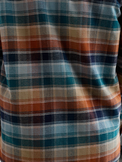 Close-up of a plaid shirt with blue, brown, and beige colors.
