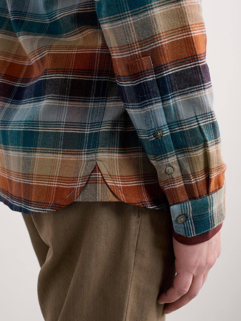 Plaid shirt with a focus on the collar and buttons, worn by a man.