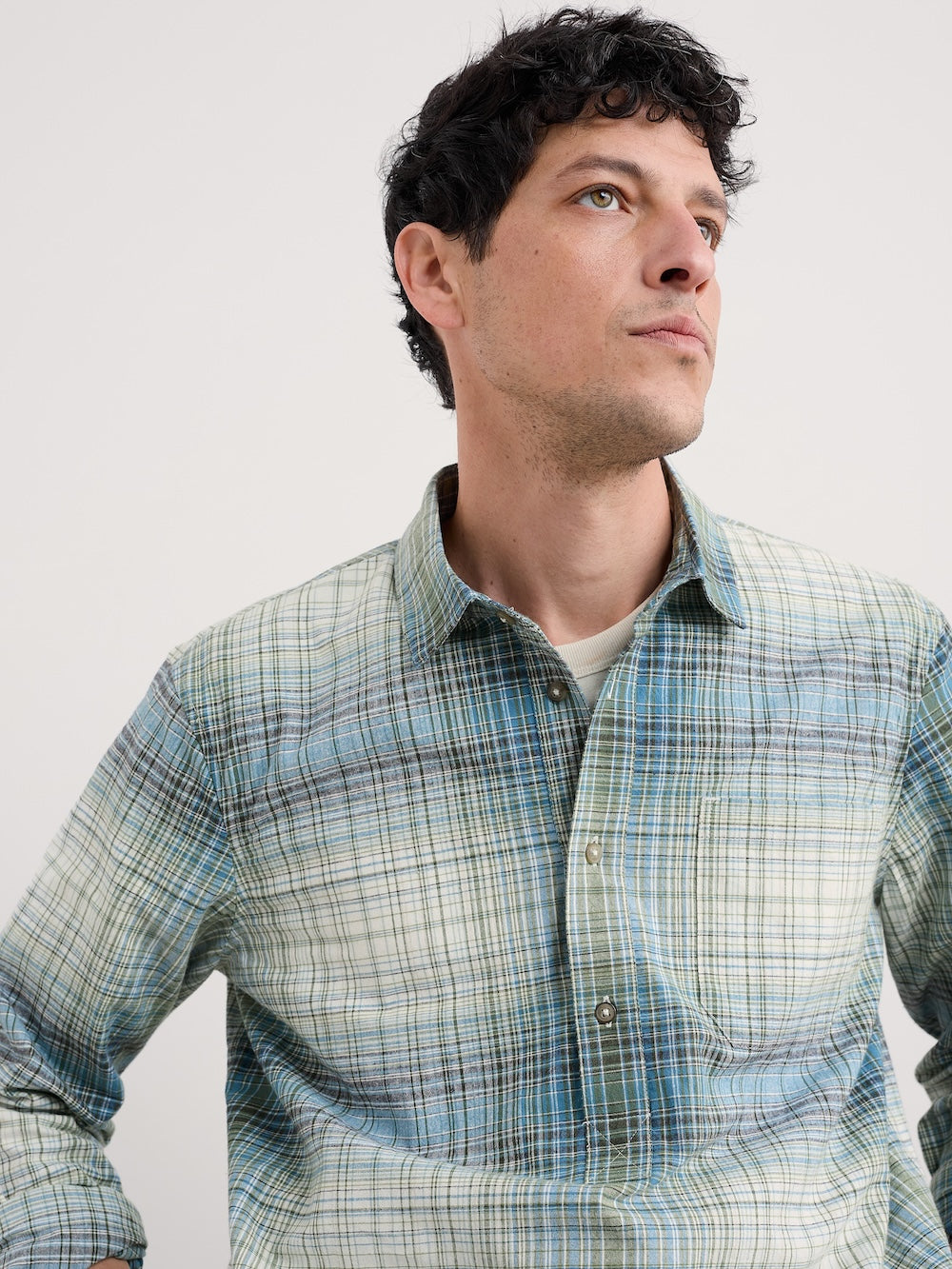 Man wearing a plaid shirt against a plain background