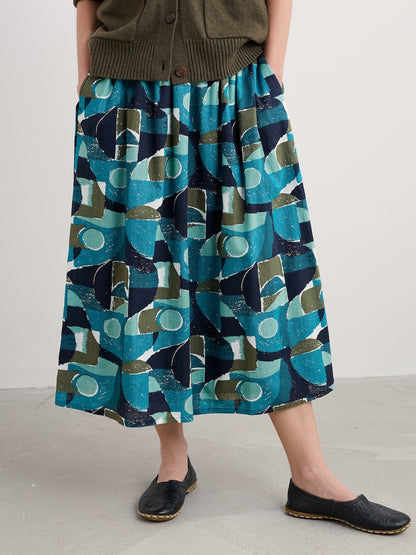 Person wearing a patterned skirt with geometric design on a plain background