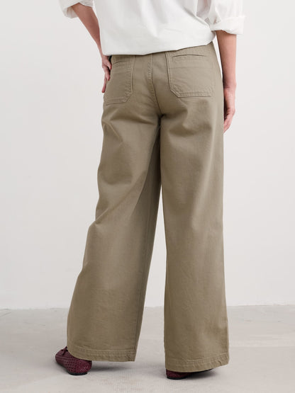 Person wearing beige wide-leg pants on a plain background