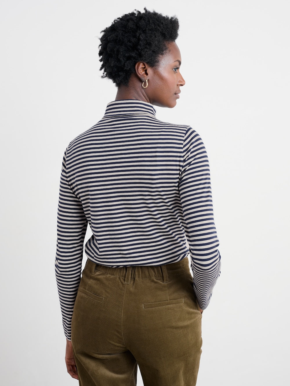 Person wearing a black and white striped shirt with a plain background