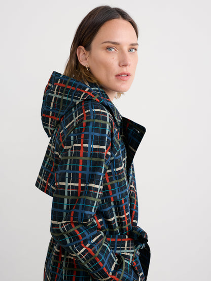 Woman wearing a plaid rain jacket on a white background